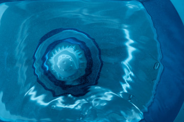 Top view of the water which is filtered through a filter in a blue decanter for water purification - 275254388