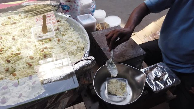 Street food- Rabri faluda, a sweet rich thick drink served with a spoon, consisting of vermicelli noodles from Indian subcontinent and Pakistan, Bangladesh.  4k 60fps close-up stabilized handheld