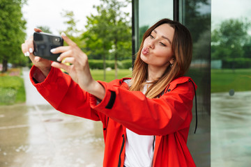 Chherful attractive young girl wearing raincoat