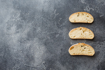 Italian ciabatta bread with olives and rosemary on a Dark concrete background. Copy space
