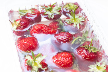 Strawberries in a bowl of water. Red berries. Seasonal berries in the water.