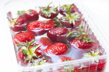 Strawberries in a bowl of water. Red berries. Seasonal berries in the water.