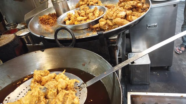 Street food- Chicken Pakora, an amazing deep fried golden brown chicken fritters covered with chickpea flour besan popular in Indian subcontinent, Pakistan.  4k 60fps close-up stabilized handheld