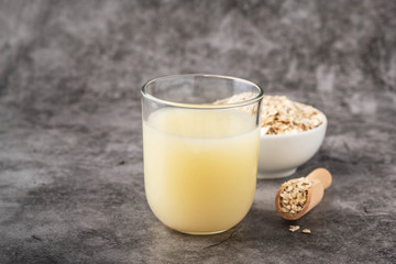 Oat milk in a glass, vegan non dairy alternative milk.