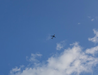 Fototapeta na wymiar plane flying in a cloud sky and cleared