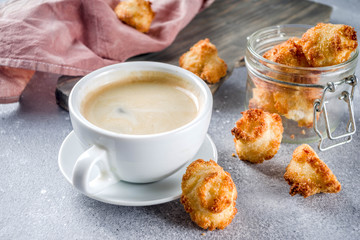 French coconut cookies congolais with coffee mug, grey stone or concrete background copy space
