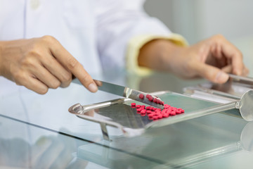 female pharmacists are counting the medicine to be packed into packages for sale to patient