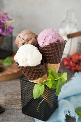 Assorted three types of ice cream in a waffle cone. Chocolate, berry and vanilla ice cream. A...