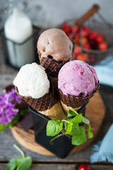 Assorted three types of ice cream in a waffle cone. Chocolate, berry and vanilla ice cream. A refreshing summer dessert. Vertical photo. Selective focus.
