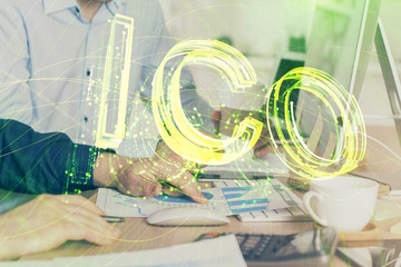 Crypto currency theme hologram with businessman working on computer on background. Concept of...