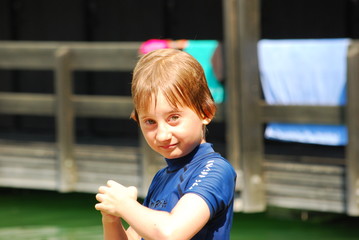 Boy wearing sun protection t-shir standy by a lake 