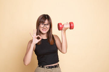 Healthy Asian woman show OK with dumbbells.