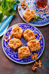 Ramadan Kareem holiday table with nuts and baklava. Eastern abundance.