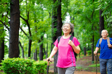 asian senior couple hiking on the forest park