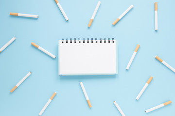 Top view notebook surrounded by cigarettes