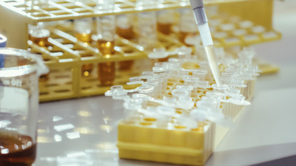 Close-up Shot of an Adding Liquid with a Micro Pipette to a Test-tubes in a Modern Laboratory. Genetics and Pharmaceutical Studies and Researches.