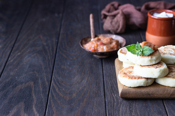 Cottage cheese pancakes or fritters with jam and mint. Traditional Ukrainian and Russian cuisine. Syrniki. Healthy and diet breakfast.