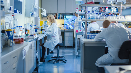 Genetic Research Scientists Work with Medical Equipment in a High Tech Research Laboratory. Female...