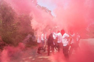 red ultras fans with torches and smokes make an ambush on the street. hooligans with red head masks...