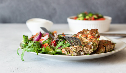 Chicken or turkey cutlets with vegetables and sauce on a plate. Delicious cutlets with salad. Selective focus.