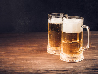 Two glasses of lager served on old wooden planks, copyspace for text