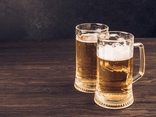 Two glasses of lager served on old wooden planks, copyspace for text