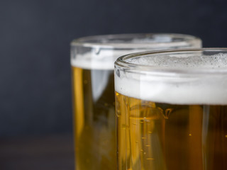 Two glasses of lager served on old wooden planks, copyspace for text