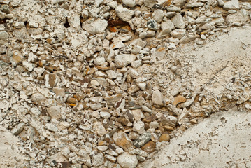 Concrete wall with gravel. Gray foundation of the house. Rust fittings in the wall.