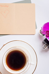 cup of coffee with diary and perfume around white background. life style flat lay
