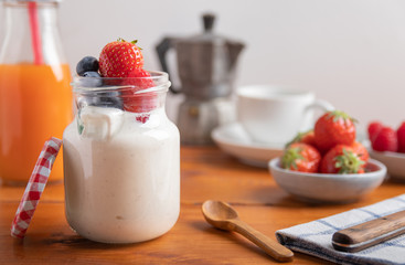 yogurt with fresh fruit and coffee on a breakfast table