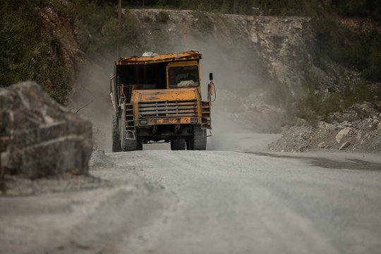 yellow truck. loaded with coal. sunny weather. kamaz bears a white breed. coal mine. extract cement 