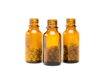 round pills in small glass orange bottles isolated on white