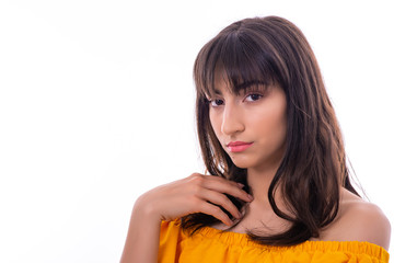 Portrait of Attractive Young Female Model. The girl poses with a yellow dress in a studio with a white background.