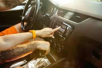 Young couple preparing for vacation trip on the car in sunny day. Woman and man sitting and ready for going to sea, riverside or ocean. Concept of relationship, vacation, summer, holiday, weekend.