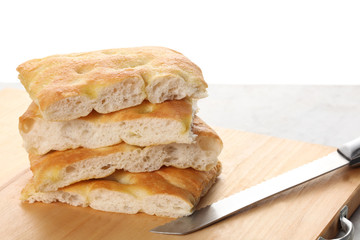 slices of traditional italian focaccia  rest on a wooden cutting board with copy space for your text