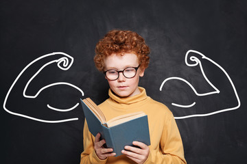 Book power. Kid reading a book on chalkboard background