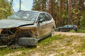 Car accident on country road in the middle of forest in June