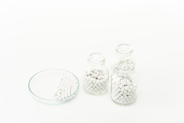 bottles with pills near glass plate isolated on white