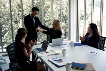 Businessmen meeting and agreeing by holding hands in the meeting room.