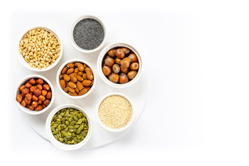 Various Nuts and Seeds on White Background in the Bowls with Free Space for Text