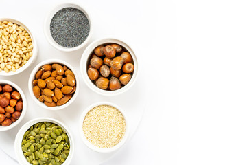 Various Nuts and Seeds on White Background in the Bowls with Free Space for Text