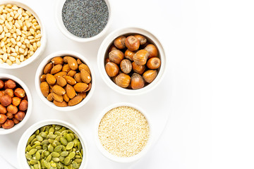 Various Nuts and Seeds on White Background in the Bowls with Free Space for Text