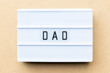 White lightbox with word dad on wood background