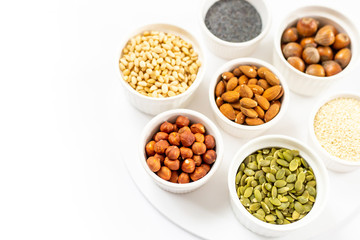 Various Nuts and Seeds on White Background in the Bowls with Free Space for Text