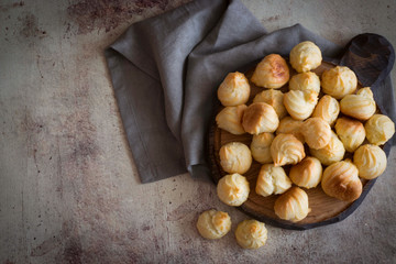 Small tasty profiteroles on a wooden Board.