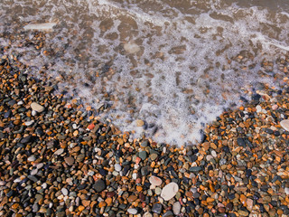 sea ​​wave foam on coastal pebbles
