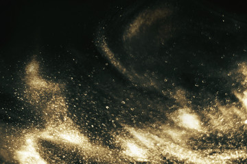 Abstract black and gold festive glitter shimmering magic luxury background. de-focused