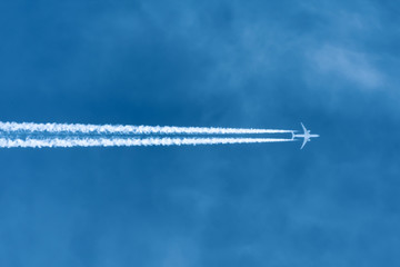 Jet aircraft flying at high altitude with contrails.