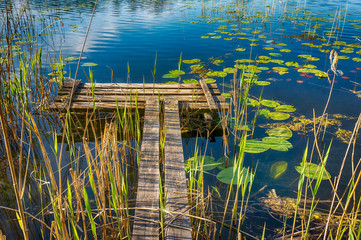 Old rustic wooden jetty on a tranquil lake