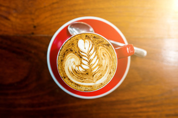 cups of cappuccino with latte art on wooden background.